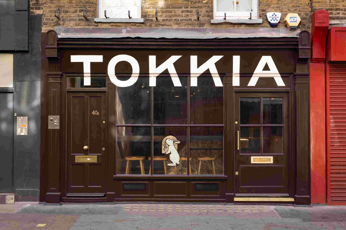 A storefront facade with large white 'TOKKIA' lettering above dark brown glass doors and windows.